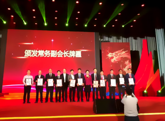 仟億達集團董事長(cháng)鄭兩斌（右1）領(lǐng)取商會(huì )常務(wù)副會(huì )長(cháng)牌匾并與福建省委常委、統戰部長(cháng)雷春美女士（右6）合影留念